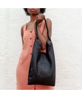 Soft and lightweight leather bag with adjustable strap that mimics plastic shopping bags.