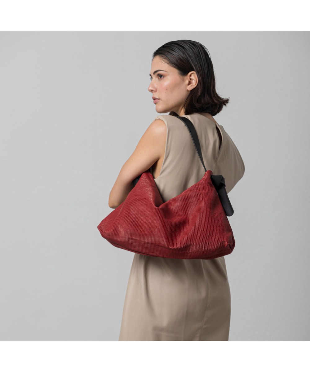 Bolso color rojo de piel suave y ligero con correa color negro..