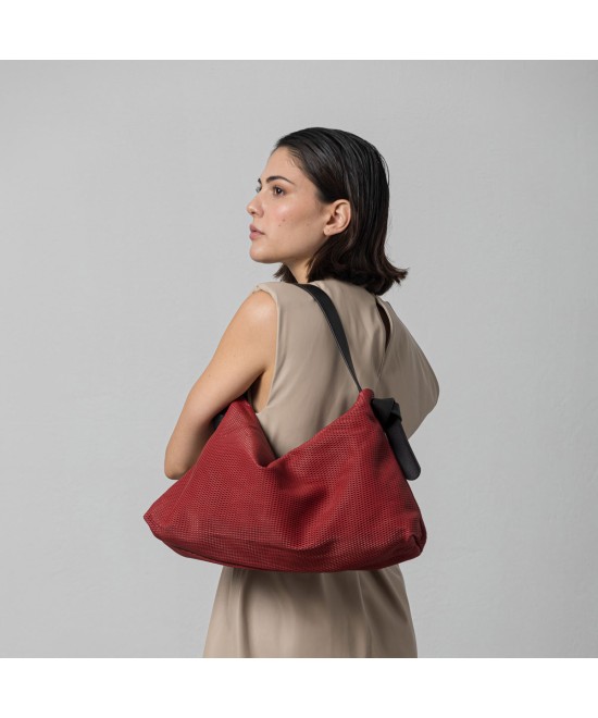 Bolso color rojo de piel suave y ligero con correa color negro..