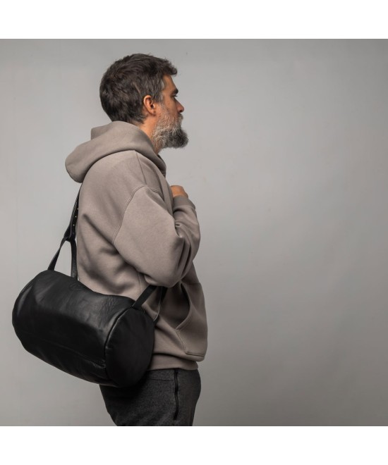 Unisex leather shoulder bag with handles and strap to cross-shoulder.