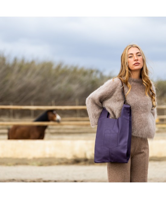 Soft and lightweight leather bag with adjustable strap that mimics plastic shopping bags.