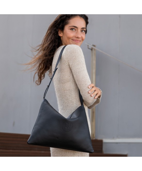 Bolso de piel amplio con correa ajustable.