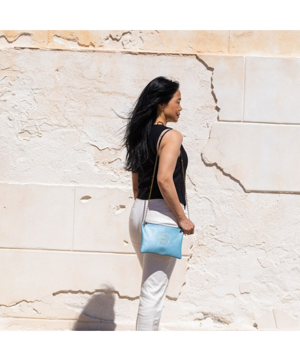 Bolso de bandolera plano de piel grabada y cadena para colgar.