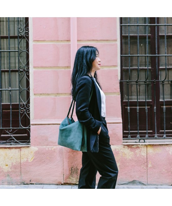 Wide leather bag with two individual departments and adjustable strap.