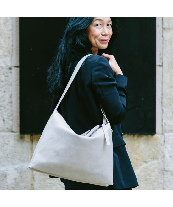 Wide leather bag with two individual departments and adjustable strap.