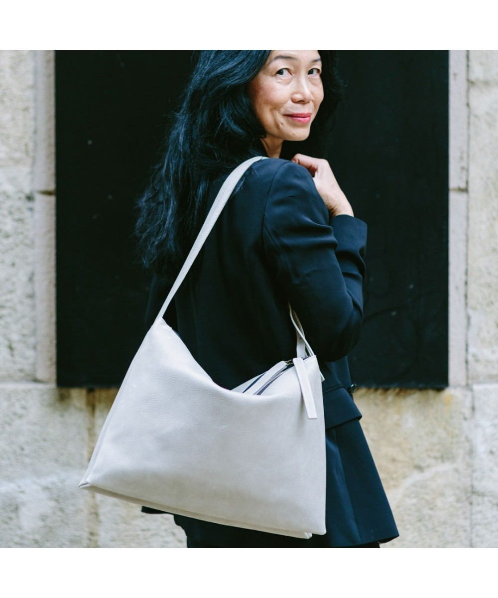 Wide leather bag with two individual departments and adjustable strap.