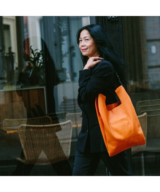 Soft and lightweight leather bag with adjustable strap that mimics plastic shopping bags.