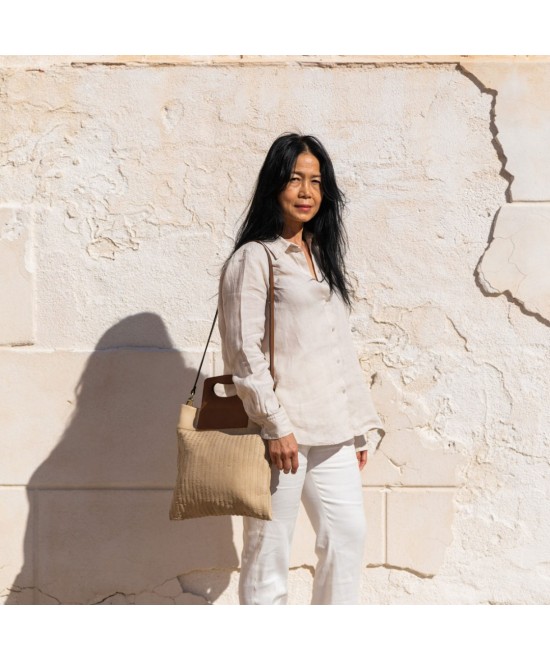 Bolso original de piel grabada con asa acolchada.