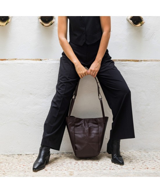 Bolso multi posición con bolsillos exteriores, asas cortas y correa larga regulable. Piel marrón